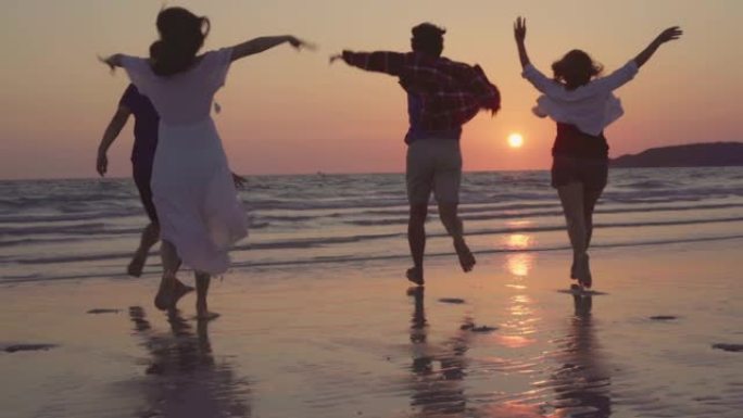 慢动作-年轻的亚洲人在海边奔跑，朋友们在傍晚日落时在海边的海滩上玩得开心，开心放松。生活方式朋友在海