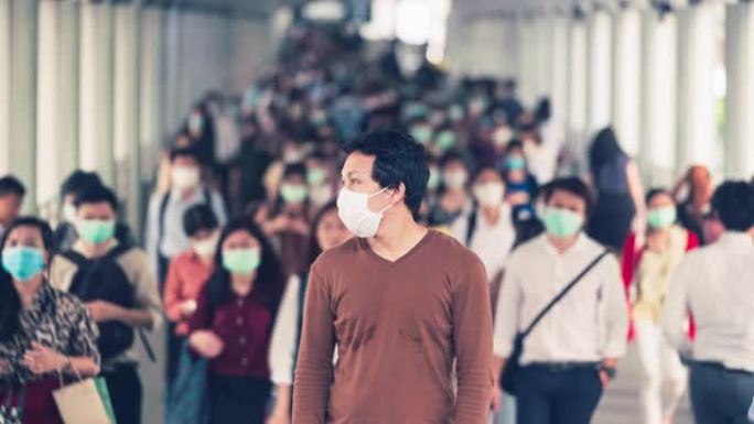 亚洲男子戴着口罩的时间流逝，以防止拥挤的人群中冠状病毒或新型冠状病毒肺炎爆发
