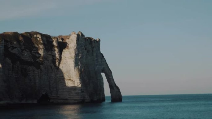 大气稳定的镜头拍摄了著名的史诗诺曼底白色粉笔拱形悬崖，日落时风景如画的全景埃特雷塔。