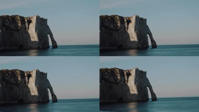 大气稳定的镜头拍摄了著名的史诗诺曼底白色粉笔拱形悬崖，日落时风景如画的全景埃特雷塔。