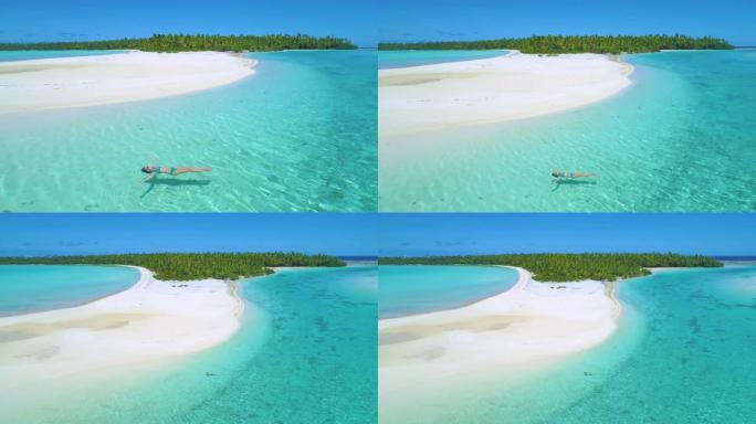 空中: 年轻女子在郁郁葱葱的异国岛屿上的玻璃海水中放松