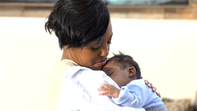 非洲裔美国母亲抱着熟睡的男婴