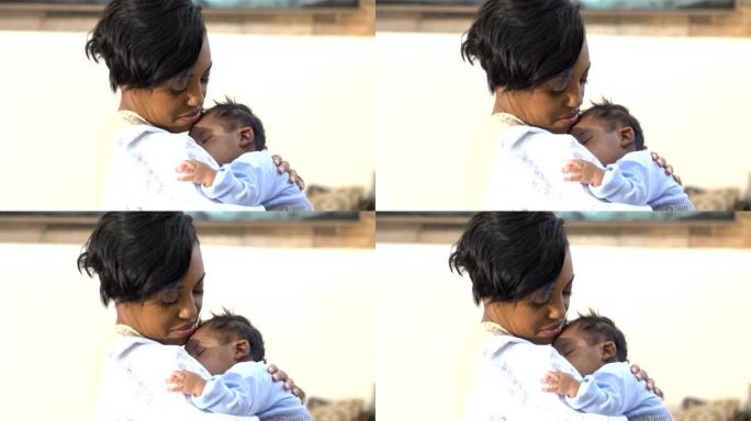 非洲裔美国母亲抱着熟睡的男婴