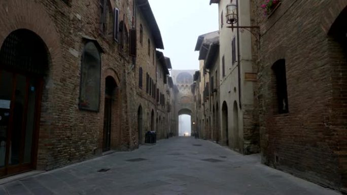 意大利圣吉米尼亚诺。走在中世纪小镇的一条狭窄街道上，充满了旧时代的光环。街道两旁有古老的砖墙建筑。4