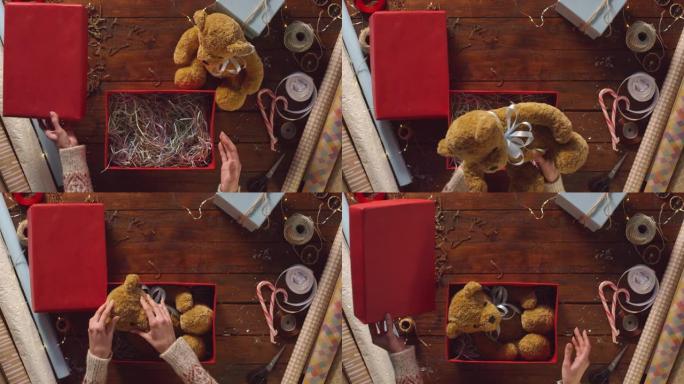 女性双手包装毛绒熊成红色礼品盒