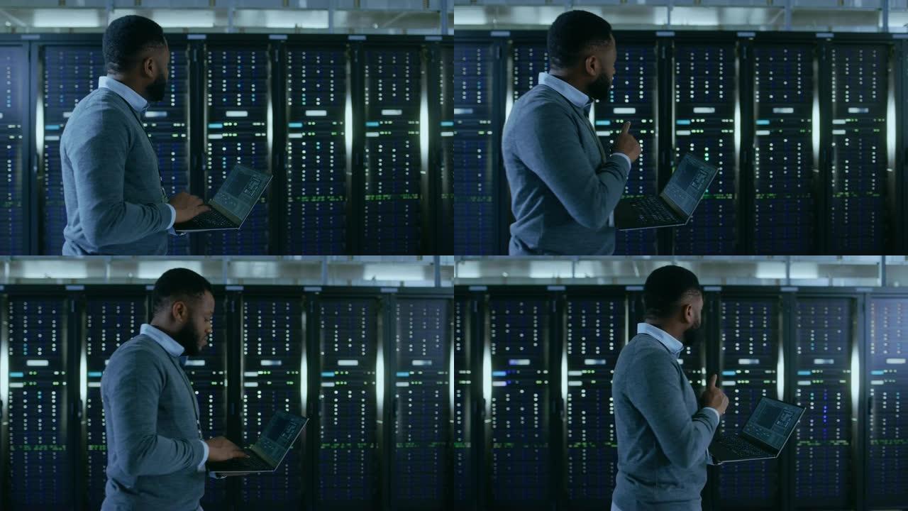 黑色数据中心it技术人员带着笔记本电脑走过服务器机架走廊。他正在目视检查工作服务器机柜。