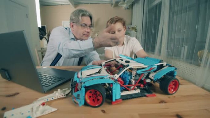 高级男子和他的孙子正在制作玩具车