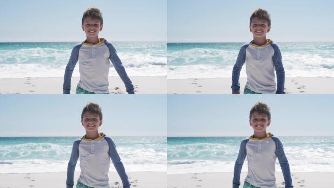 男孩站在海滩上看着相机
