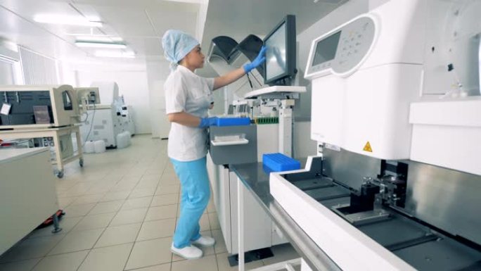 专家站在生化分析仪附近，并与自动制药设备一起工作。