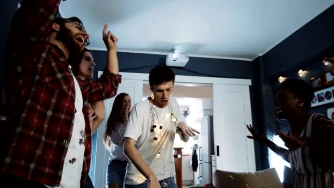 千禧一代欧洲男学生快乐，在多民族生日派对慢动作中与朋友跳舞
