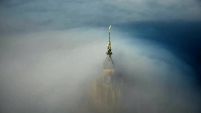史诗圣米歇尔山城堡尖顶的大气空中俯视图，被浓雾覆盖，流入黑暗。