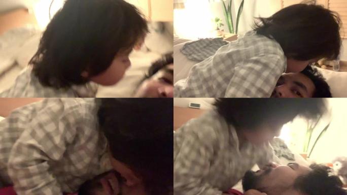 亚洲家庭与一个快乐的儿子在床上玩耍