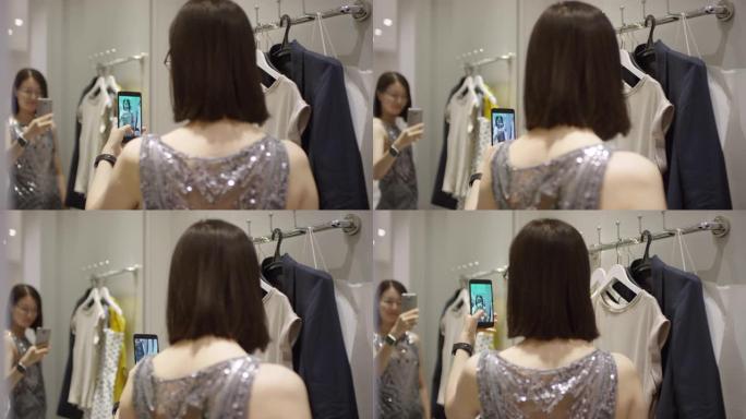 亚洲女孩在商店里的镜子里穿着派对礼服自拍