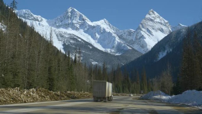 交通沿着艾伯塔省雪山下的乡间小路移动。
