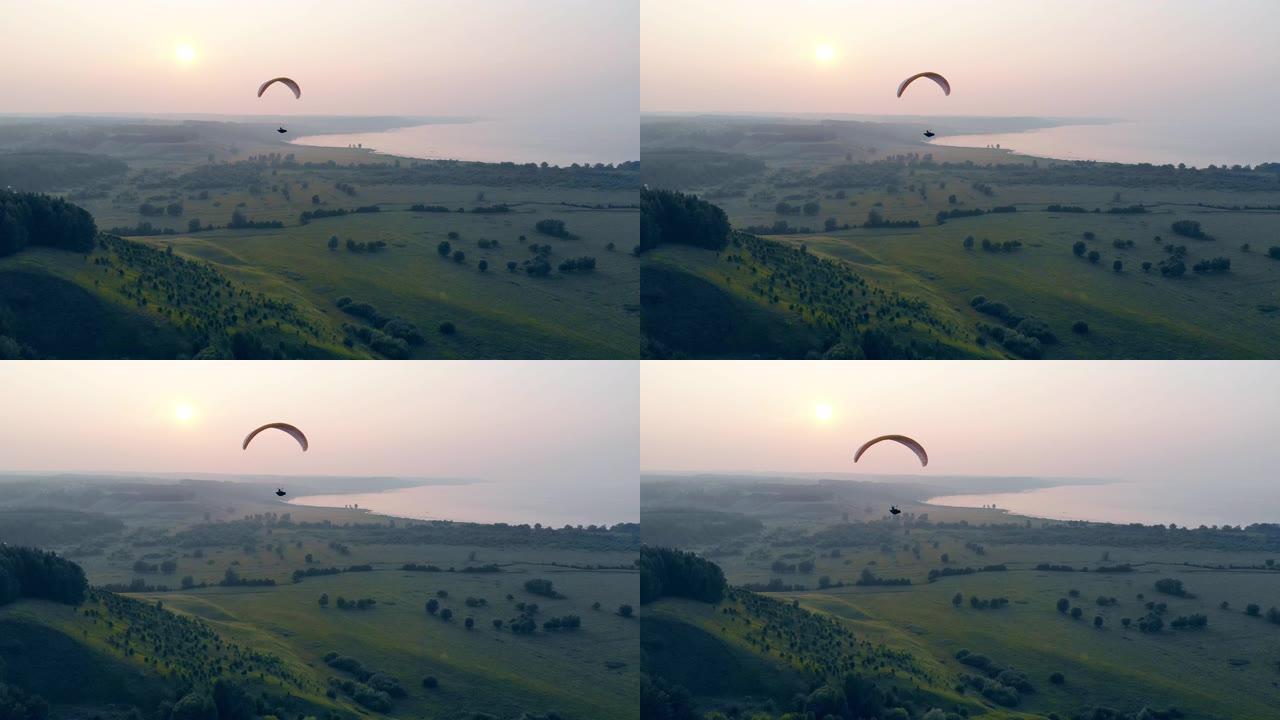 绿色雾蒙蒙的风景，翼状旁板沿着它漂流。降落伞，滑翔伞。