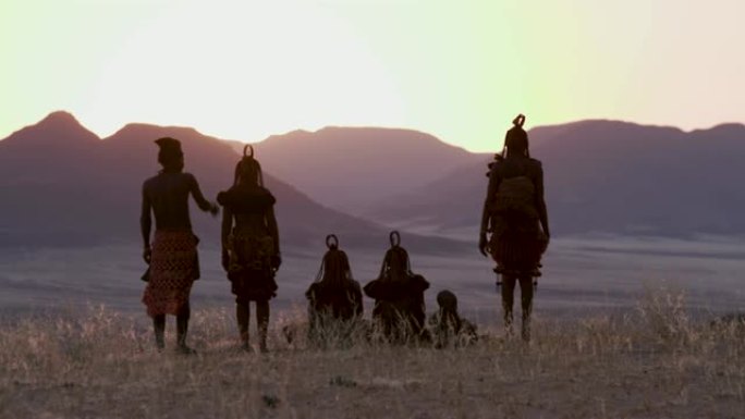 纳米比亚纳米布沙漠中，身着传统服饰的希姆巴部落的人们观看日落的4K画面