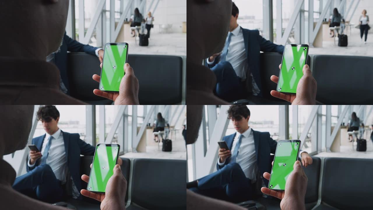 当商人坐在机场候机室时，用手机拍摄的黑屏特写