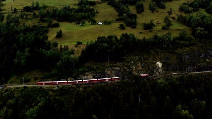 无人机跟随著名的红色冰川快车进入史诗般的夏季瑞士阿尔卑斯山的Landwasser桥和隧道。