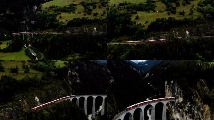 无人机跟随著名的红色冰川快车进入史诗般的夏季瑞士阿尔卑斯山的Landwasser桥和隧道。