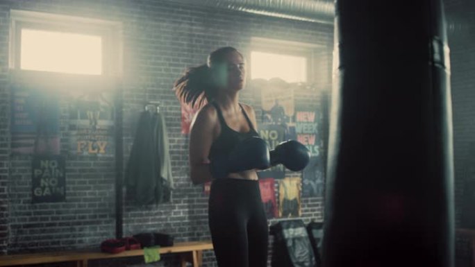 健身运动女性跆拳道运动员在阁楼健身房用激励海报锻炼时拳打脚踢。经过激烈的自卫训练，她筋疲力尽。