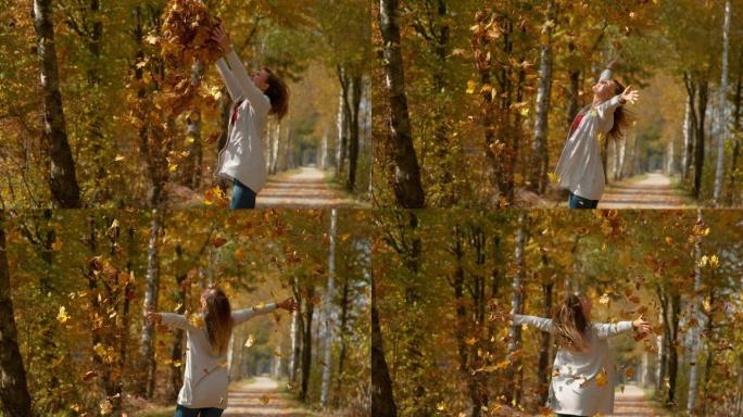 复制空间: 快乐的女人将一堆秋天的彩色叶子高高抛向空中。