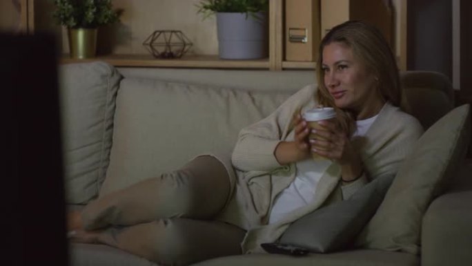 开朗的女人喝咖啡看电影