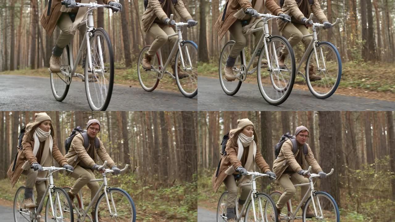 男人和女人在秋天的森林里骑自行车
