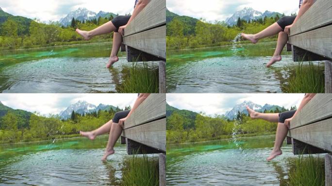 女士慢动作无忧无虑的年轻女子在田园诗般的山湖中泼水。