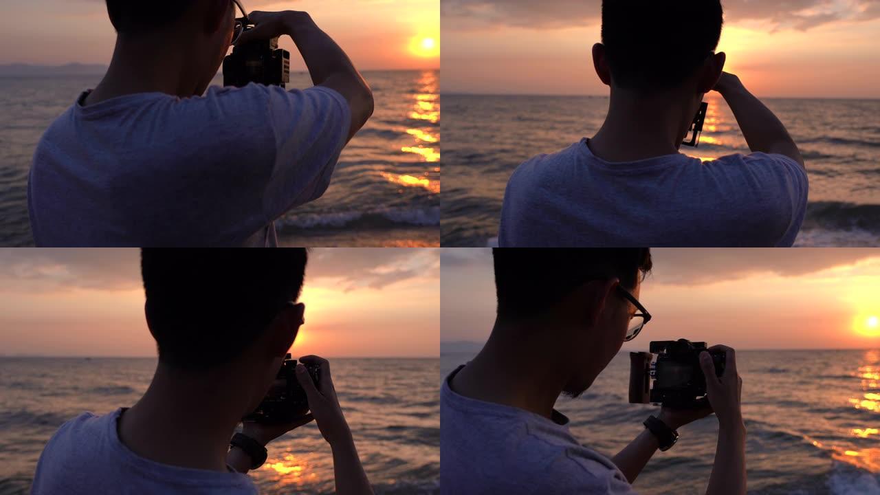 CU男子在海滩上拍摄日落或日出的视频和照片