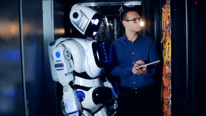 男性IT程序员和机器人，droid在数据中心工作。