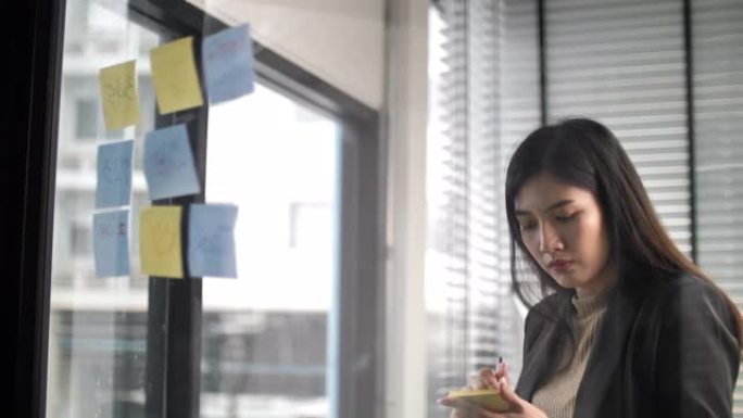 女性头脑风暴使用粘性笔记在创意办公室
