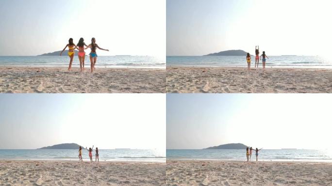三个漂亮的女孩在海滩上跑步和玩耍。假期-iStock