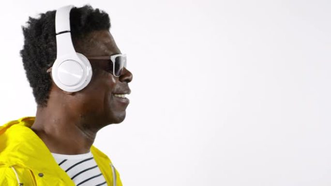 非洲男子戴着耳机听音乐，微笑着