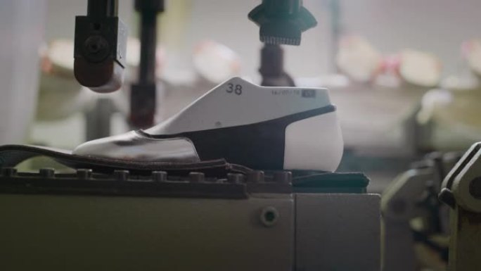 鞋匠在鞋厂中使用意大利传统打磨鞋子的轮廓时的特写镜头。
