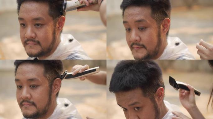在户外用理发推子剪发的男人脸部特写