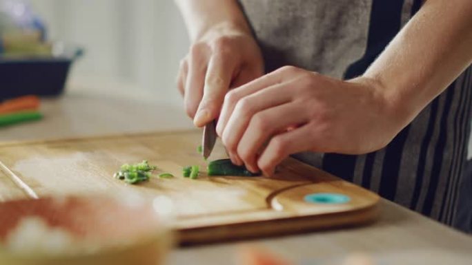 一名男子用锋利的菜刀切碎青辣椒的特写镜头。在现代厨房准备健康的有机沙拉餐。天然清洁饮食和健康的生活理