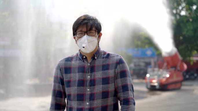 亚洲男子站在消防救援车上用消防水带飞溅喷水空气污染问题背景