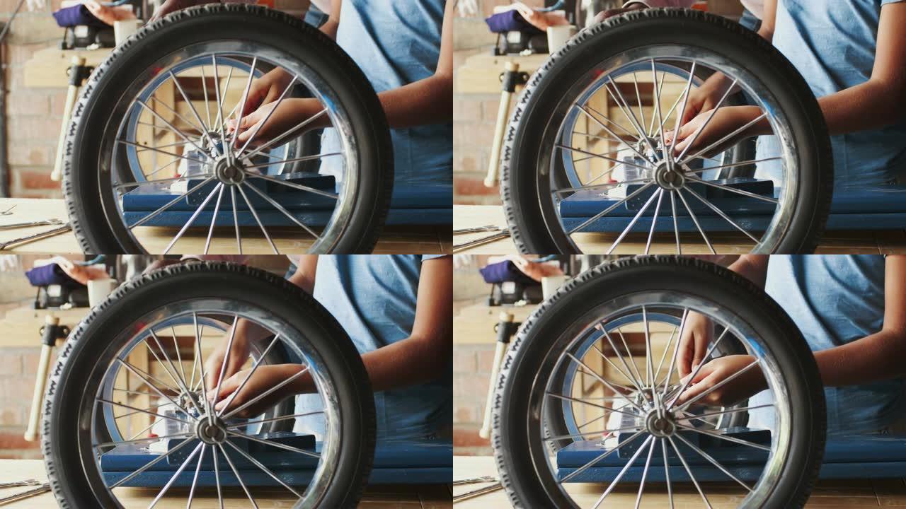 十几岁的男孩使用扳手将车轮连接到他的赛车卡丁车，中间部分细节，通过车轮的辐条可以看到