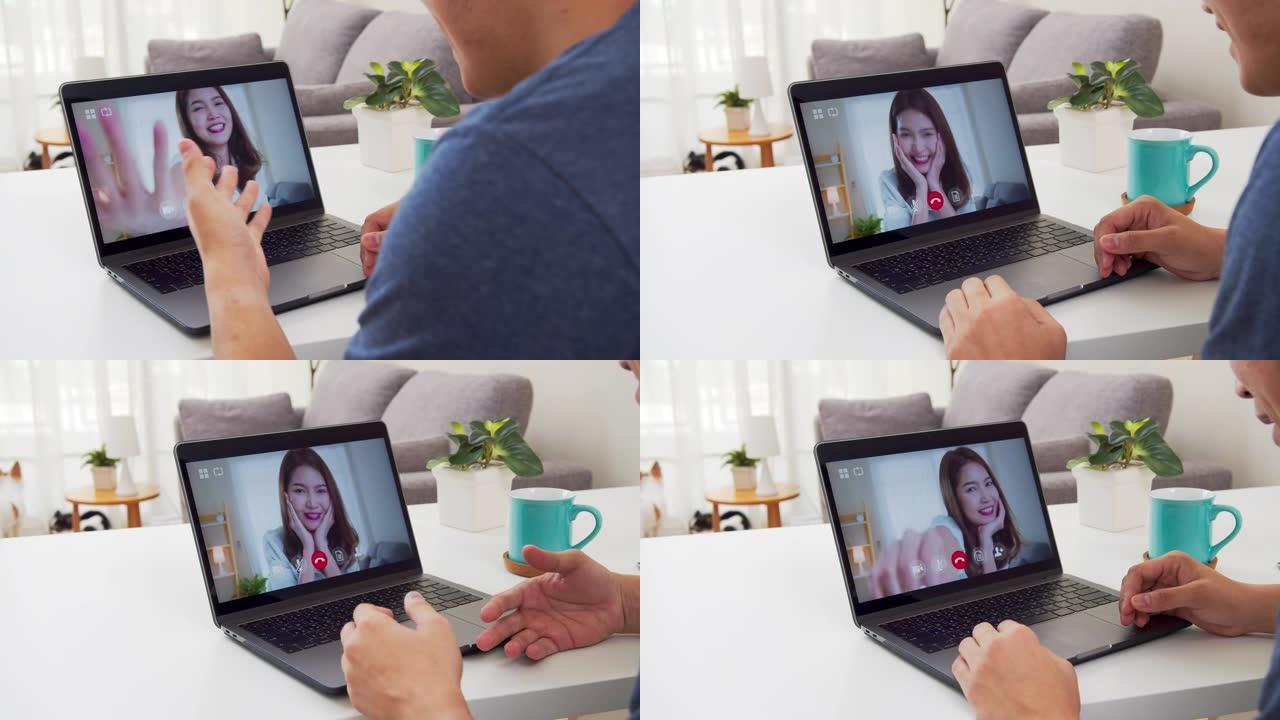 亚洲男子视频通话或视频会议的肩视图与女朋友感到幸福。亚洲夫妇在冠状病毒自助隔离时通过笔记本电脑在线连