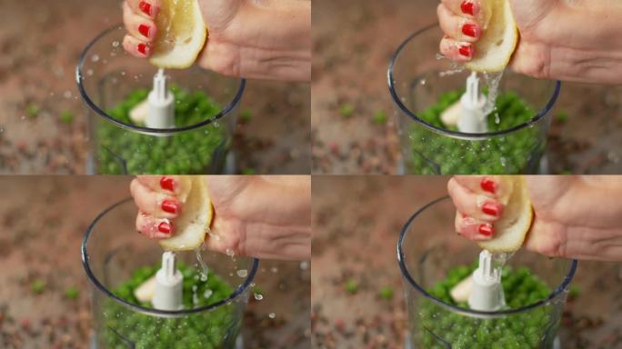 宏观: 女厨师将有机柠檬挤入装满生豌豆的搅拌机中。