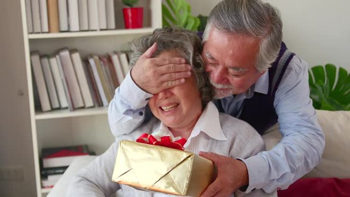 年迈的丈夫让妻子大吃一惊。走到后面，然后在结婚周年纪念日或生日那天，把手放在眼睛里，并赠送一个礼品盒