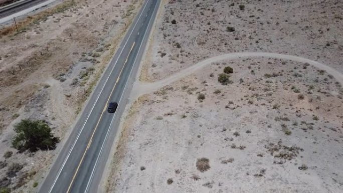在美国亚利桑那州令人惊叹的夏天，无人机跟随银色汽车沿着华丽的沙漠路行驶。公路旅行旅行概念。