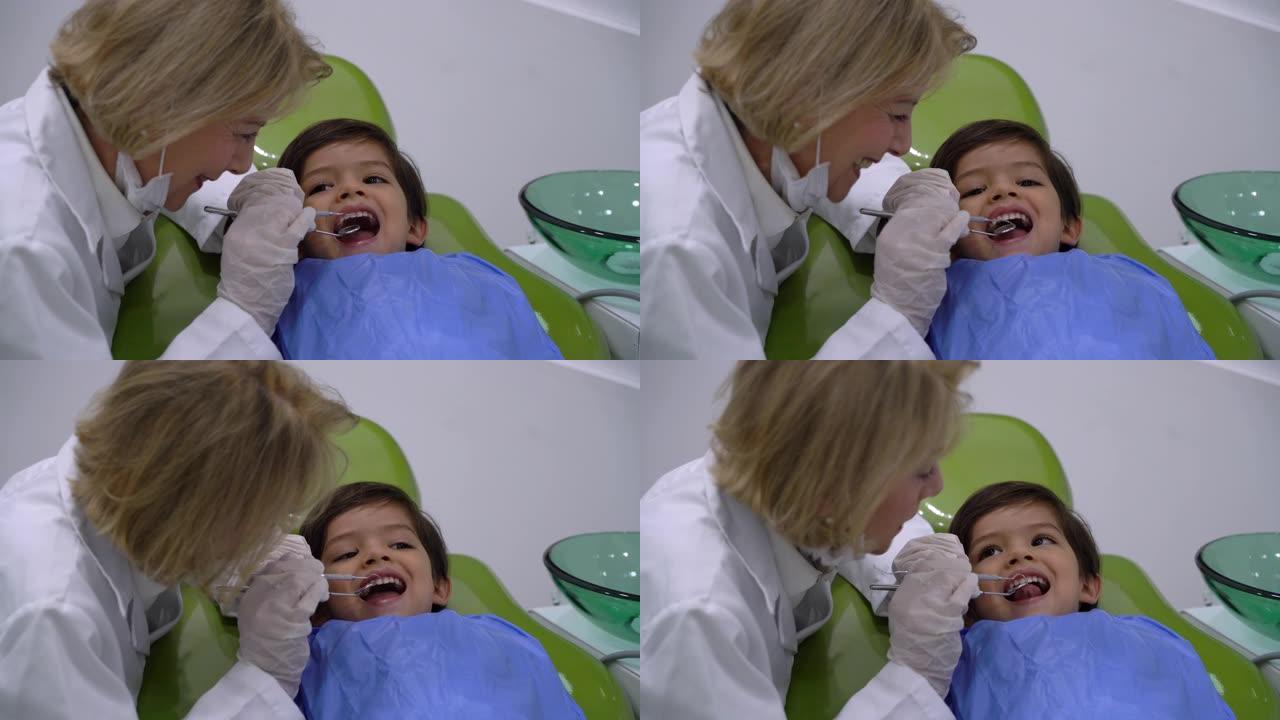 爱心女牙医很调皮地检查一名男儿科患者的牙齿
