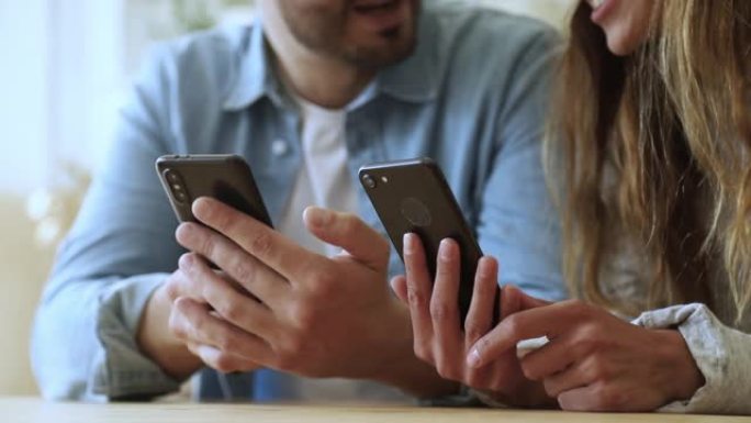 年轻夫妇使用智能手机应用会笑，特写镜头