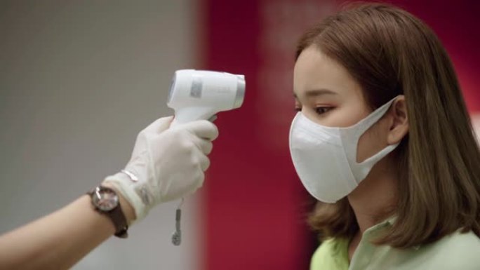 病人亚洲妇女脸和手用温度计检查温度
