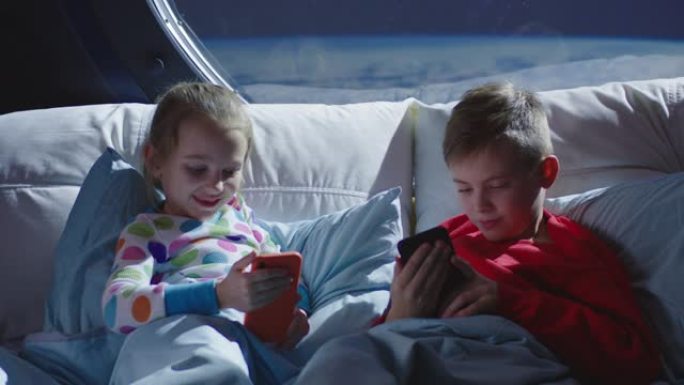 男孩和女孩在床上使用手机