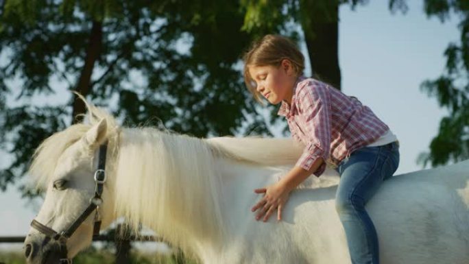 一张真实的照片，一个可爱的小女孩躺在一匹白马上，在阳光下抚摸着她骑在马厩里
