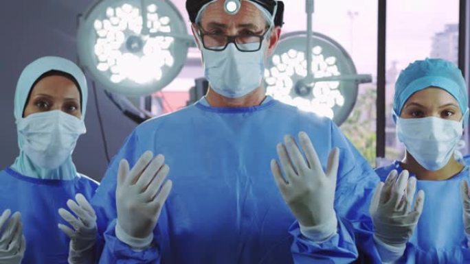 站在医院手术室时打手势的外科医生的前视图