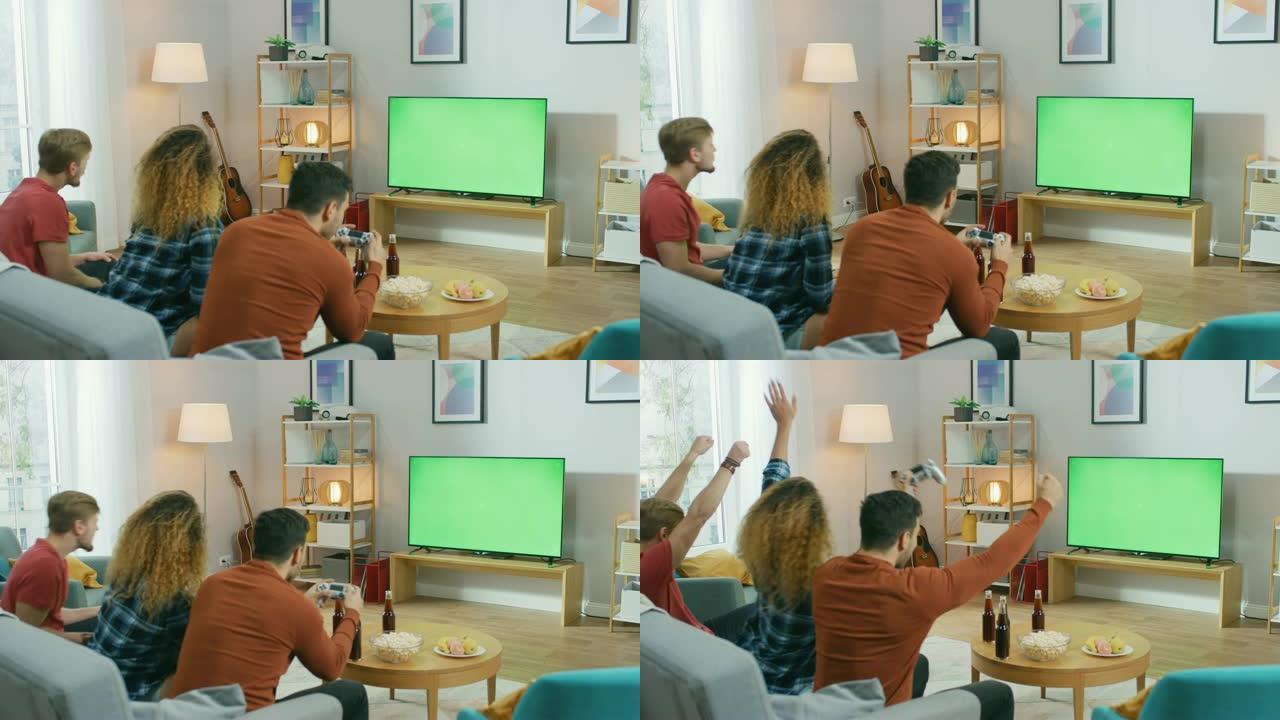 在客厅里，三个朋友使用控制器在绿色色度键屏幕上玩视频游戏。青少年在家里玩得开心。