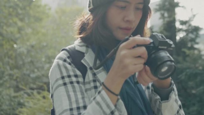 年轻的亚洲女性在中央公园用数码单反相机拍摄图像。纽约